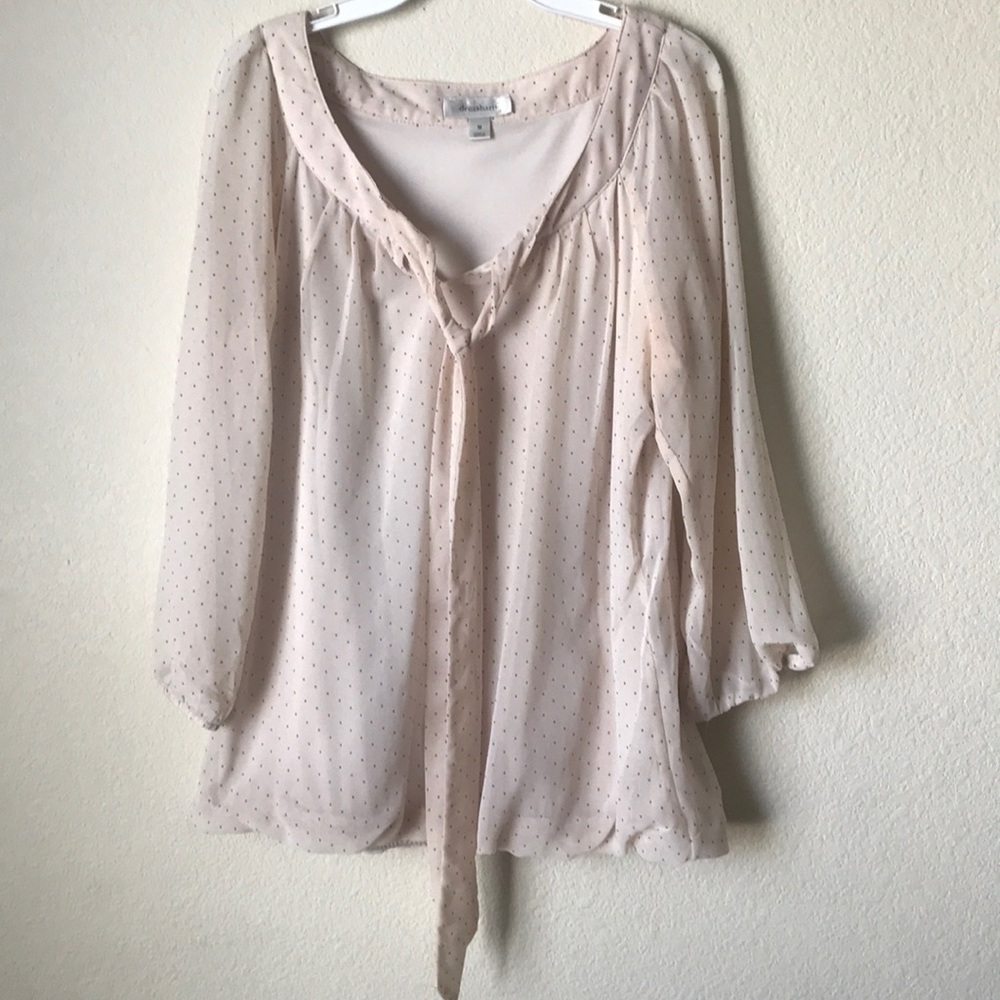 This is a blouse shirt with black dots